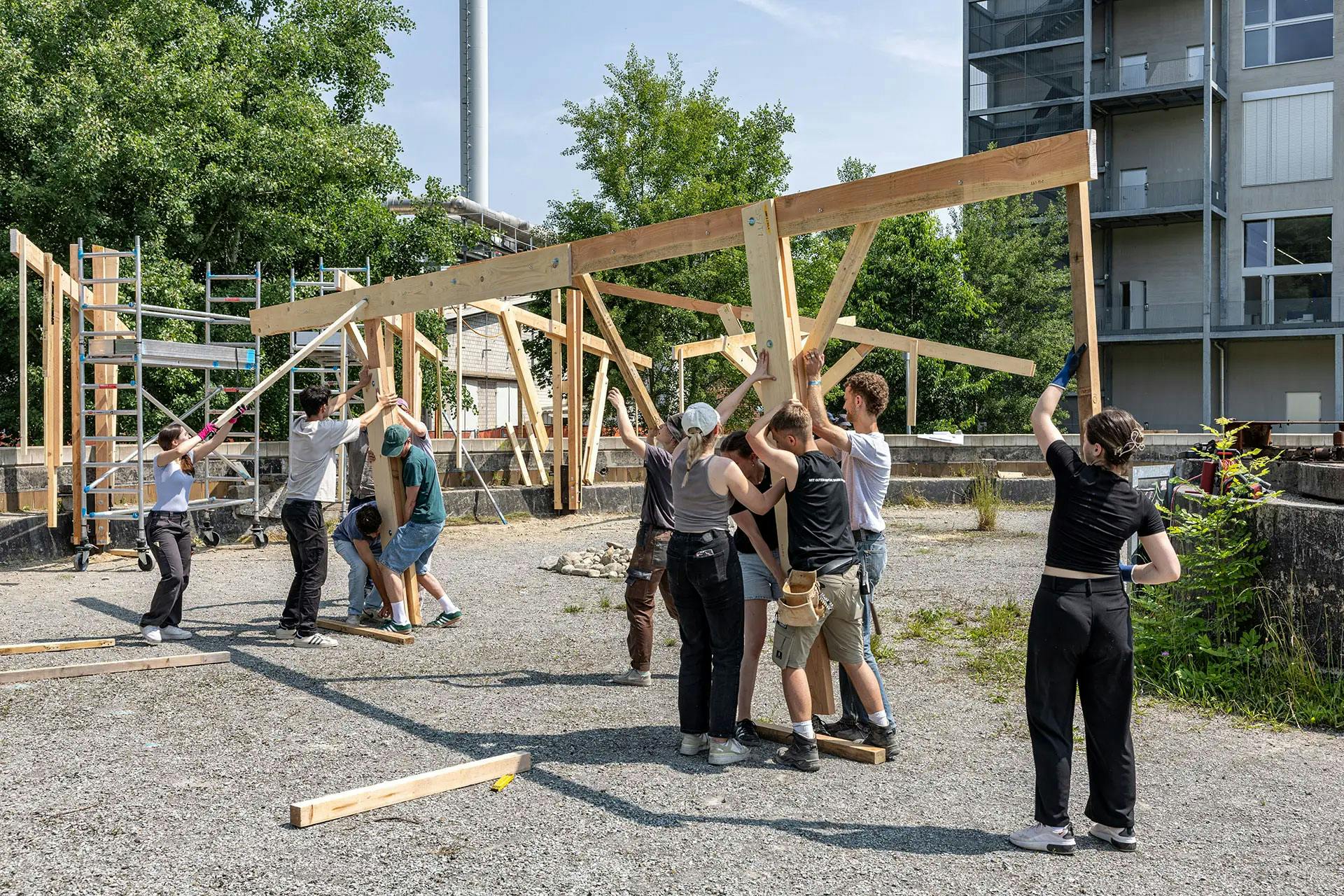 Studierende stellen eine Holzkonstruktion auf.